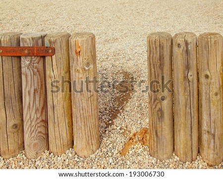 Broken old wooden palisade, old wooden stockade, fence, stony background