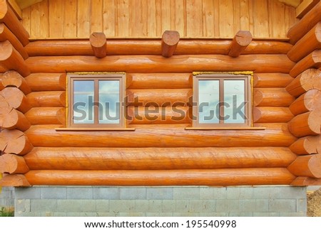 Detail of beams in cabin wall. Painted wood with fungicide light red paint.