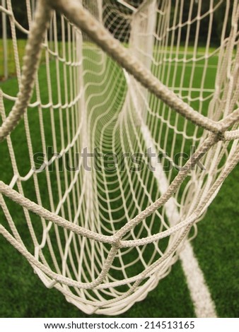 Hang bended soccer nets, soccer football net. Plastic grass and white painted line on football playground in the background
