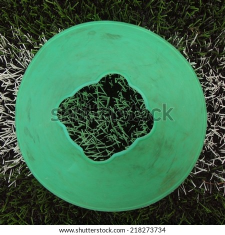 Bright green blue plastic cone on painted white line. Plastic football green turf playground with grind black rubber in core.