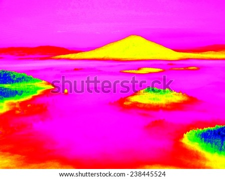 Colorful infrared photo of hilly landscapewith colorful fog, hot sunny sky above. Amazing thermography colors.