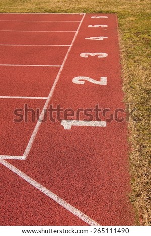 White track number on sprint start. The red rubber racetrack small stadium, texture of running racetracks.