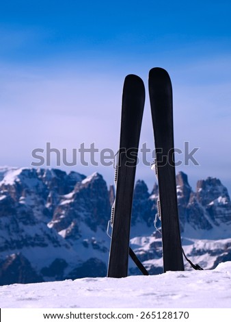 Small fun skis in snow at mountains, nice sunny winter day at peak