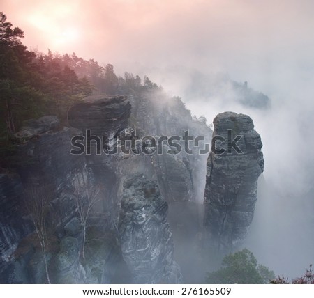 Spring early morning view over sandstone rocks to fall valley of Saxony Switzerland. Sandstone peaks of rocky empires hills increased from colorful background.
