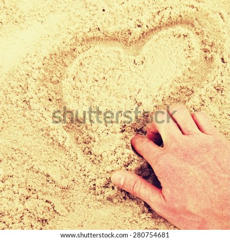 Hand draw heart in the wet sand on the coast