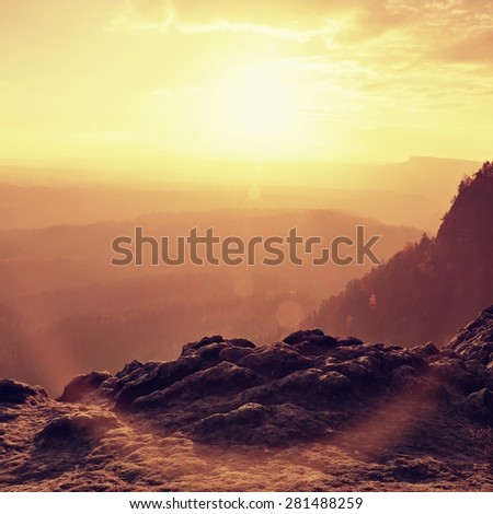 Autumn sunset view over sandstone rocks to fall colorful valley full of sun rays