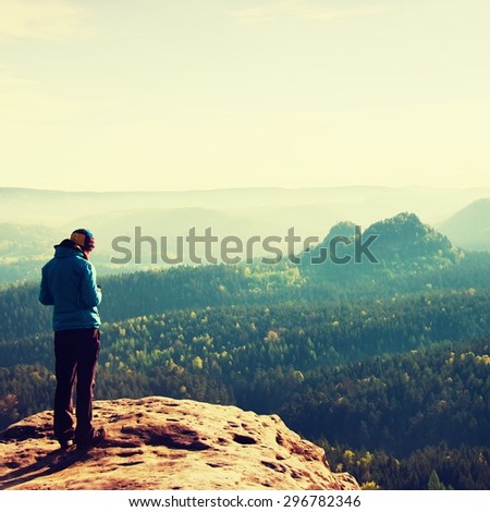 Hiker stand on the sharp corner of sandstone rock in rock empires park and watching over the misty and foggy morning valley to Sun.