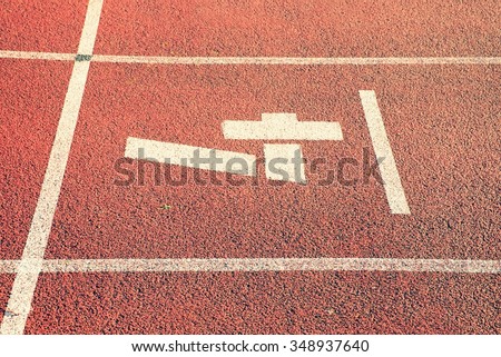 Number four. White track number on red rubber racetrack, texture of racetracks in small stadium