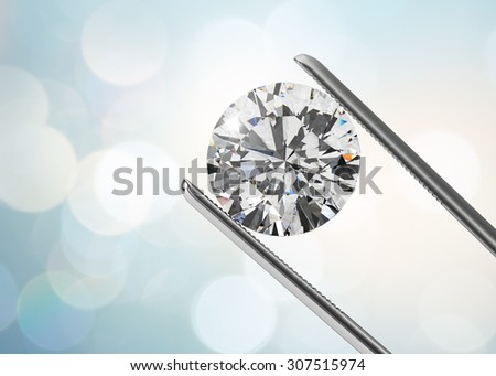 Luxury diamond in tweezers closeup with bright bokeh background