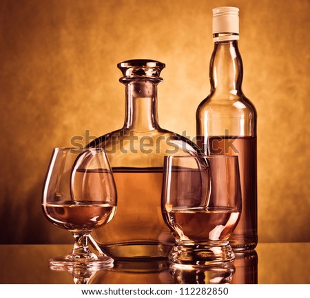 Whiskey and cognac bottles with filled glasses