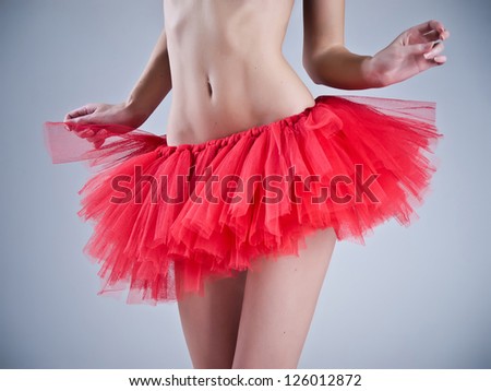 Torso of a female dancer wearing a red skirt