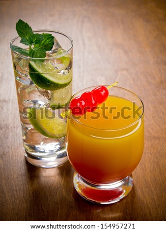 Two cocktails, tequila sunrise and gin and tonic