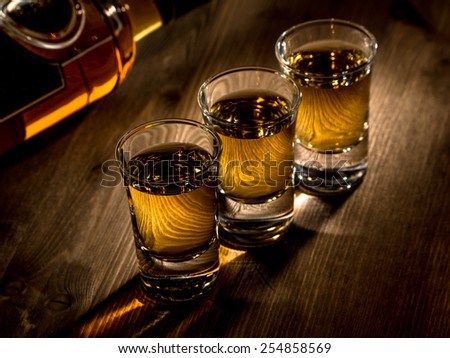 Three shots of whisky on a bar top