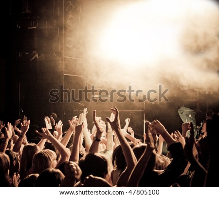 Crowd at a music concert, audience raising hands up