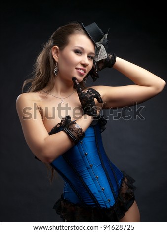 Half body portrait of attractive young woman in vintage style dance clothes with small top hat; studio background.