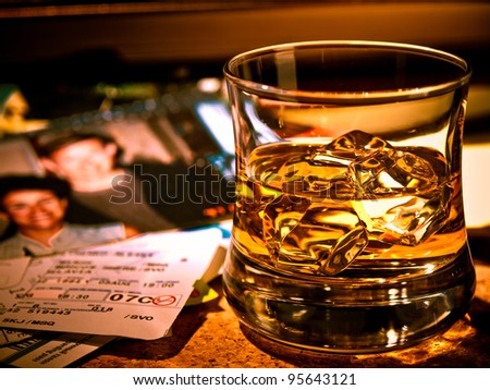 A glass of whiskey on the table, diary books, a photo from some good times, tickets, boarding passes. It\'s all memory.