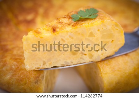 Portion of Spanish tortilla (omelette) displayed with a tortilla as background