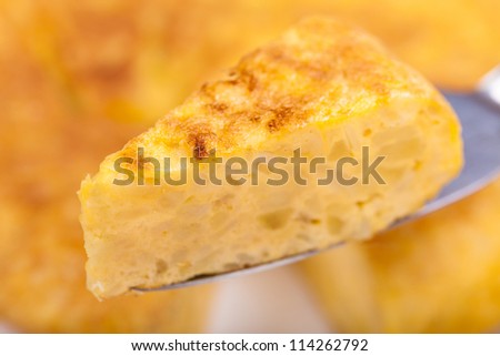 Portion of Spanish tortilla (omelette) displayed with a tortilla as background