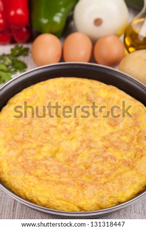 Fresh homemade Spanish tortilla (omelette) in the frying pan, and some ingredients. By far the most popular Spanish tapa