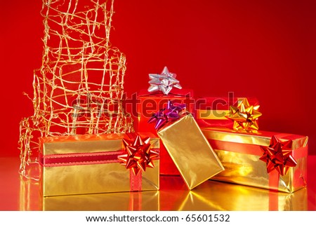 Golden gift boxes under a modern Christmas tree, on red background