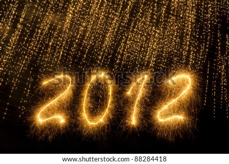 2012 written in sparkling letters over a golden sparks curtain