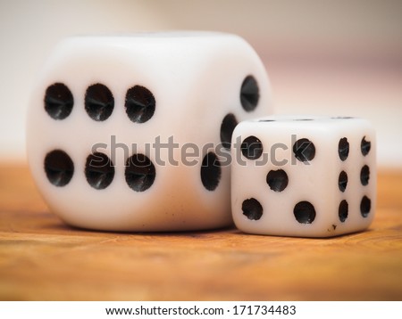 a small and a big dice on a table