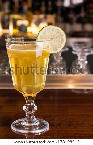 Yellow cocktail with lime decoration