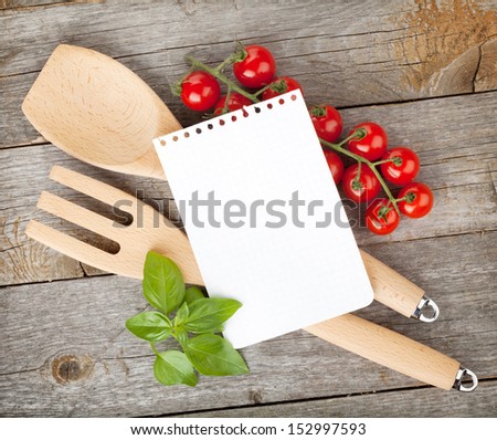 Blank notepad paper for your recipes with tomatoes and basil on wooden table