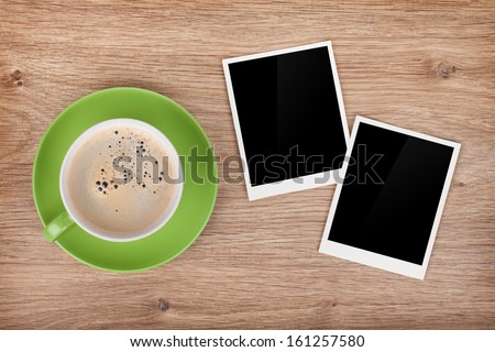 Cup of coffee and two photo frames on wooden table