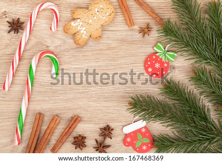 Christmas fir tree, gingerbread cookie and candy cane on wooden background