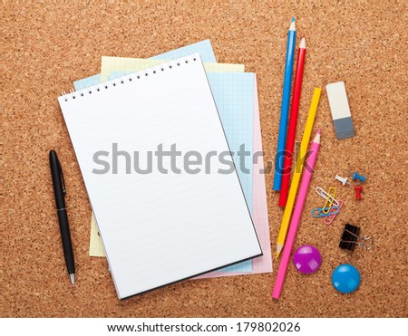 Blank notepad on cork wood notice board with office supplies Blank notepad on cork wood notice board with office supplies
