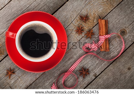 Red coffee cup and spices on wooden table. View from above