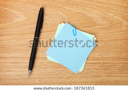 Blank post-it with pen on office wooden table. Above view