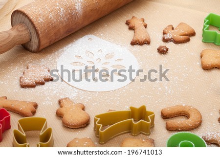 Rolling pin and gingerbread cookies on cooking paper