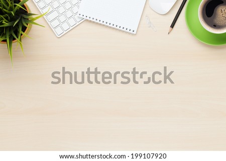 Office table with notepad, computer and coffee cup. View from above with copy space