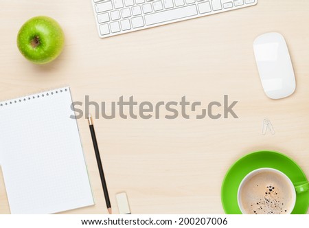Office table with notepad, computer and coffee cup. View from above