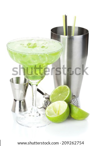 Classic margarita cocktail with salty rim, limes and drink utensils. Isolated on white background