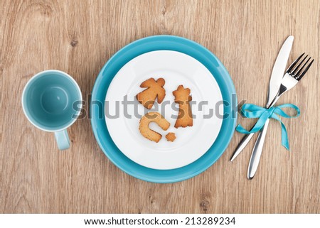 Kitchen utensils over wooden table with cookies on plate