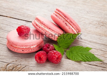 Pink raspberry macaron cookies on wooden table background