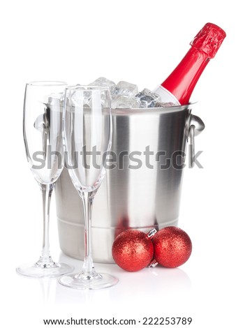 Champagne bottle in ice bucket, two empty glasses and christmas decor. Isolated on white background