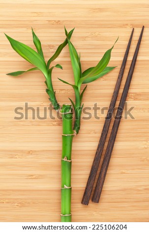 Bamboo plant and chopsticks on wooden table