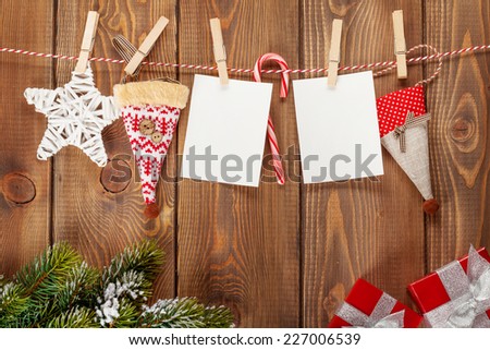 Snow fir tree, photo frames and christmas decor on rope over rustic wooden board with copy space