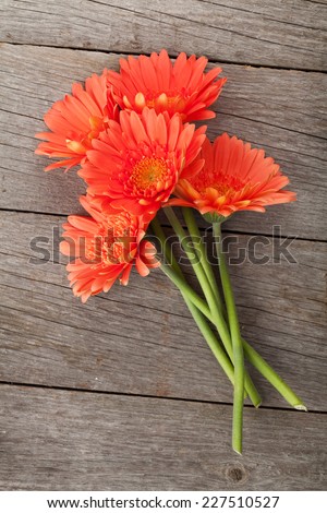 Bouquet of orange gerbera flowers over wooden background