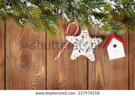 Snow fir tree and christmas decor over rustic wooden board with copy space