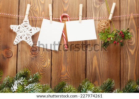 Snow fir tree, photo frame and christmas decor on rope over rustic wooden board with copy space