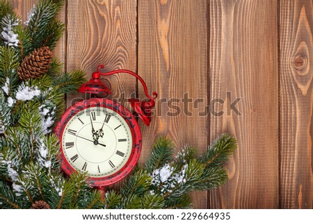 Christmas wooden background with clock, snow fir tree and copy space