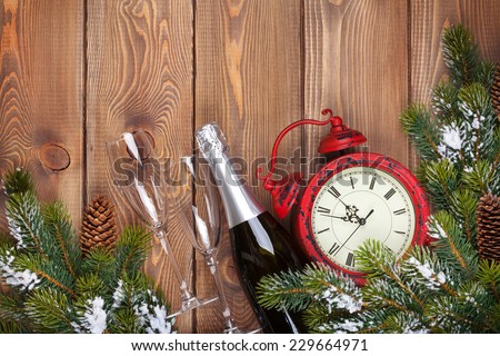 Christmas wooden background with clock, champagne, snow fir tree and copy space