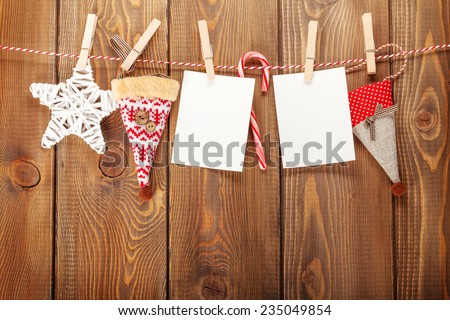 Photo frames and christmas decor on rope over rustic wooden board with copy space