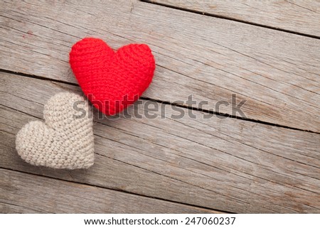 Valentines day background with handmade toy hearts over wooden table