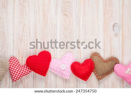 Valentines day background with toy hearts over white wooden table